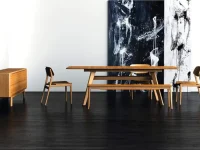 DS4 - A mid-century modern dining set with a smooth bamboo honey-toned wooden table and chairs on a dark hardwood floor