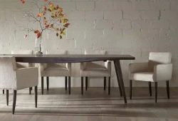 DS8 - Espresso-finished table paired with textured cream upholstered chairs against a soft white brick wall
