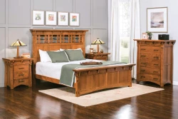 Arts and Crafts bedroom set in quarter sawn oak featuring lattice headboard bed matching nightstands and chest with craftsman lamps and colorful gallery wall
