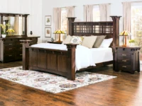 Bedroom collection in dark oak featuring four poster bed dresser and nightstands with Mission style lamps floral rug and craftsman stained glas