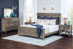 Coastal farmhouse bedroom collection in weathered gray featuring panel bed dresser and nightstands with navy accents blue glass vases and seascape artwork