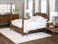 Dark stained four-poster bed with high headboard and low footboard matching nightstands and dresser, finished in the same rich, medium-dark wood
