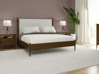 Mid century modern bedroom set with walnut frame upholstered headboard matching nightstands and dresser featuring tripod lamps and tropical plant accent