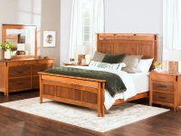 Mission style bedroom furniture featuring panel bed with vertical slats matching dresser and nightstands in honey oak finish with green velvet bedding