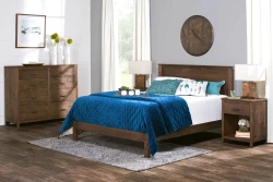 Modern farmhouse bedroom set with dark wood frame bed matching dresser and nightstands featuring navy quilted bedding and turquoise feather accent pillows