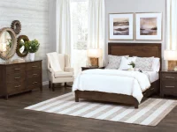 Modern industrial bedroom set in dark walnut featuring panel bed dresser and nightstand with metal hardware decorative gear mirrors and watercolor landscape artwork