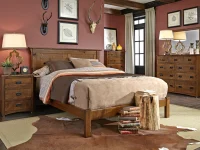 Rustic craftsman bedroom set with planked headboard bed and coordinating case pieces in distressed oak featuring antler decor and botanical prints