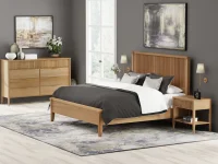Scandinavian modern bedroom collection in natural oak with reeded panel bed dresser nightstand brass sconces and abstract art against gray walls