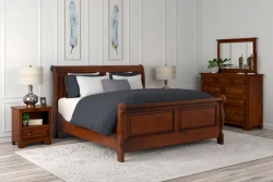 Traditional Louis Philippe sleigh bed set in warm cherry featuring curved panels dresser and nightstand with mercury glass lamps and blue feather artwork