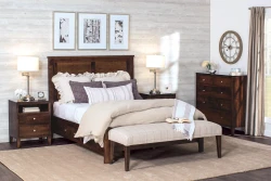 Traditional bedroom suite in rich brown featuring panel bed matching nightstands and chest with plaid bench monochromatic artwork and brushed nickel lamps