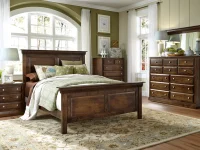 Traditional panel bed set in distressed walnut featuring crown molding dresser with mirror nightstands and chrome knobs styled with sage floral bedding