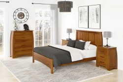 Transitional solid oak bedroom collection with panel bed chest and nightstands in honey finish featuring black hardware abstract art and oversized drum pendant