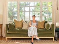 Rowe - A cozy living room with a green velvet sofa adorned with pillows