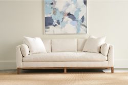 Rowe - Beige Sofa With White Pillows Under Abstract Painting On Neutral Wall, On Woven Rug, Home Decor