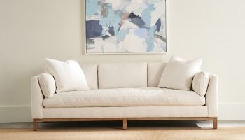 Rowe - Beige Sofa With White Pillows Under Abstract Painting On Neutral Wall, On Woven Rug, Home Decor