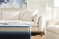 Rowe - Cream Sofa With Plush Cushions Near White Lamp And Ottoman Under Abstract Art Home Decor