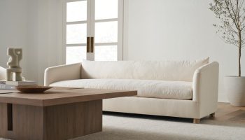Rowe - Cream Sofa With Plush Cushions Near Wooden Coffee Table In Minimalist Living Room With White Walls And Large Windows