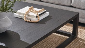 Rowe - Dark Wood Coffee Table With Books And Decor On Woven Rug Near Grey Sofa With Blue Pillow