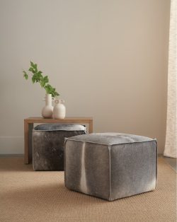 Rowe - Gray Cowhide Ottomans Under Wooden Console Table With White Vases And Green Leaves, Home Decor