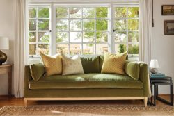 Rowe - Green Velvet Sofa With Yellow And White Pillows Under Large Window Near Wooden Side Table