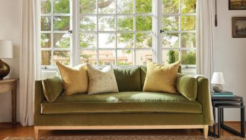 Rowe - Green Velvet Sofa With Yellow And White Pillows Under Large Window Near Wooden Side Table