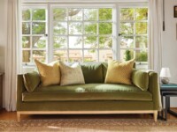 Rowe - Green Velvet Sofa With Yellow And White Pillows Under Large Window Near Wooden Side Table