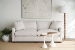 Rowe - Light Gray Sofa With Plush Cushions Near Two White Nesting Tables Under Abstract Art