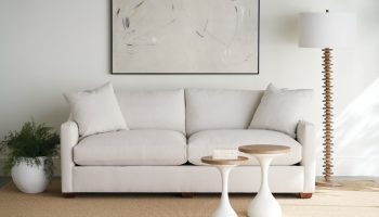 Rowe - Light Gray Sofa With Plush Cushions Near Two White Nesting Tables Under Abstract Art