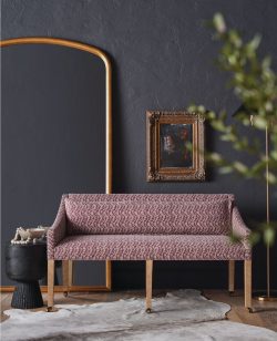 Rowe - Pink Patterned Sofa With Wooden Legs On Cowhide Rug Near Gold Mirror And Framed Art