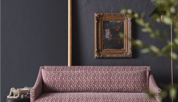 Rowe - Pink Patterned Sofa With Wooden Legs On Cowhide Rug Near Gold Mirror And Framed Art