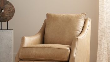 Rowe - Tan Leather Swivel Chair With Plush Cushions On Woven Rug Near Abstract Sculpture