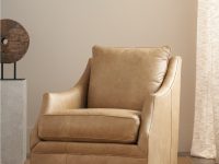 Rowe - Tan Leather Swivel Chair With Plush Cushions On Woven Rug Near Abstract Sculpture