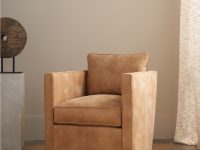 Rowe - Tan Swivel Armchair With Plush Cushions On Woven Rug Near Abstract Sculpture