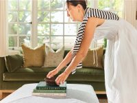 Rowe - White Coffee Table With Books And Decor In Front Of Green Velvet Sofa With Patterned Pillows