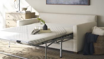 Rowe - White Sleeper Sofa With Pull-Out Mattress Near Wooden Dresser And Wicker Basket, Home Decor