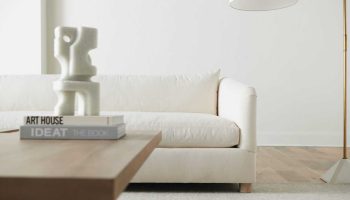 Rowe - White Sofa With Wooden Coffee Table Near Modern Sculpture And Floor Lamp In Minimalist Home Decor
