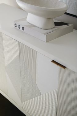 Rowe - White console table with geometric ribbed panel doors, topped with a white bowl and a book