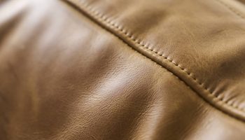 Rowe - close-up view of tan leather upholstery section featuring finely stitched seam running vertically