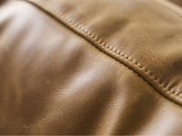 Rowe - close-up view of tan leather upholstery section featuring finely stitched seam running vertically