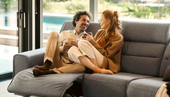 Content couple relaxing on light grey Stressless Emily Wide sofa