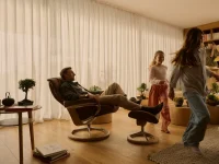 Dad relaxing in dark caramel Stressless Mayfair recliner while kids play