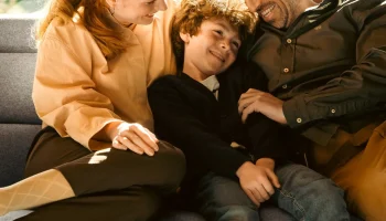 Happy family cuddling on grey Stressless Emily sofa