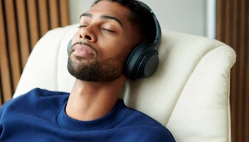 Man listening to music in vanilla walnut Stressless Max recliner closeup