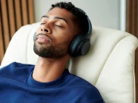 Man listening to music in vanilla walnut Stressless Max recliner closeup