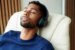 Man listening to music in vanilla walnut Stressless Max recliner closeup