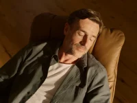 Man peacefully napping in caramel leather Stressless Mayfair recliner