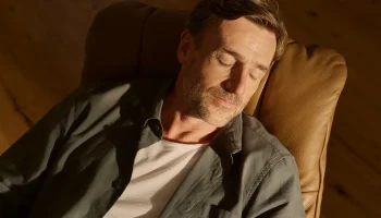 Man peacefully napping in caramel leather Stressless Mayfair recliner